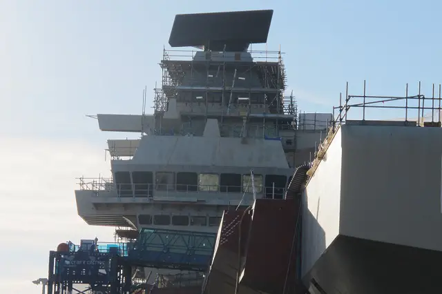 The Royal Navy’s future flagship now stands 56 metres (183ft) tall – higher than Nelson’s Column – after the enormous Goliath crane lifted the 8.4-tonne long-range radar into place on top of the carrier’s forward island. The Thales SMART-L radar safely arrived in Rosyth with its support, the mast cap, from Hengelo in the eastern Netherlands back in September.