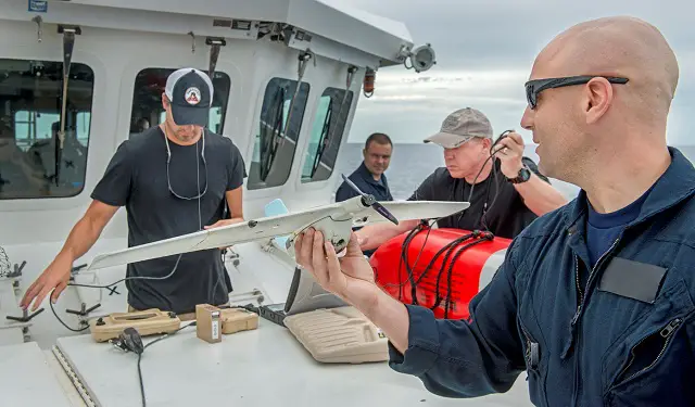 Lt. j.g David Steele from Sector Miami Response prepares to launch a WASP III while Dr. Andrew Niccolai and Timothy Ledbetter man the ground control station. U.S. Coast Guard photo by Petty Officer 2nd Class Luke Clayton.