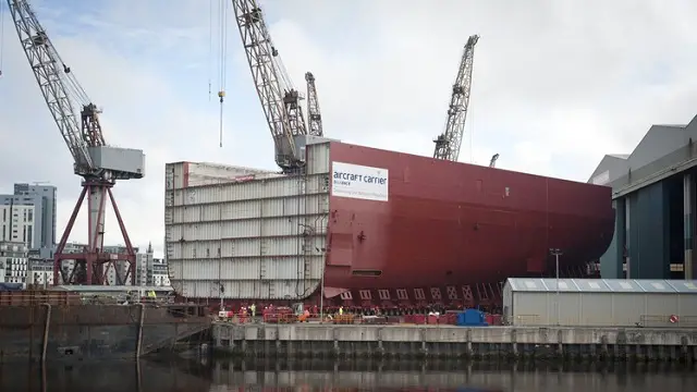 Workers at BAE Systems on moved sunday the biggest section of HMS QUEEN ELIZABETH, the first of two new aircraft carriers for the Royal Navy, out of the company’s shipbuilding hall at Govan for the first time.